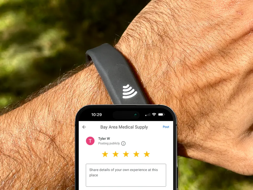 A silicone NFC wristband tapping a phone to open its action